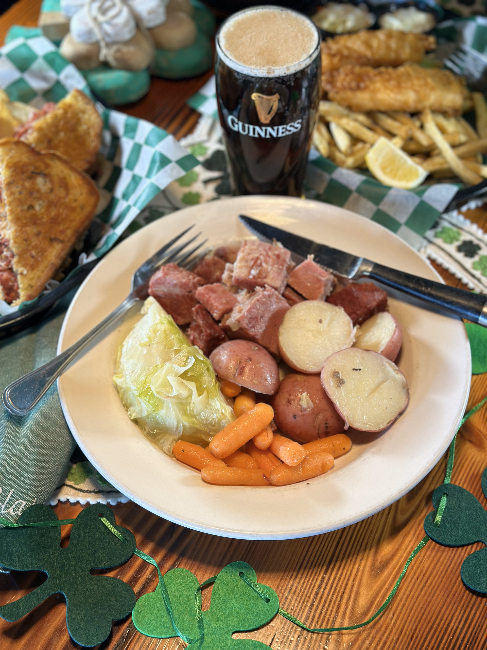 A plate of food and a glass of guinness beer on a table.