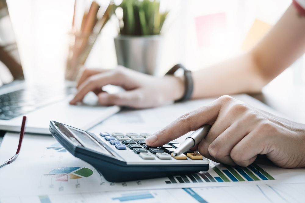 A Person is Using a Calculator at a Desk — Townsville Accounting In Hyde Park, QLD
