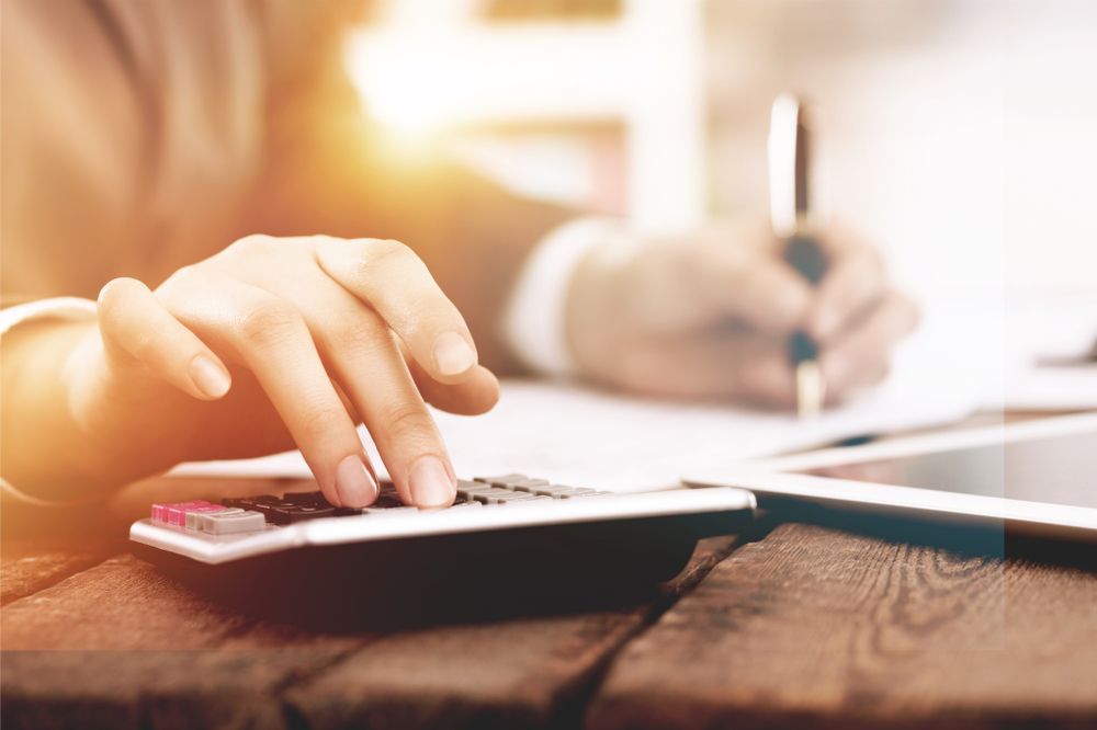 A Person is Using a Calculator — Townsville Accounting In Hyde Park, QLD