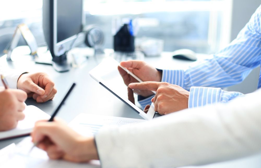 A Group of People Are Looking at a Tablet — Townsville Accounting In Hyde Park, QLD