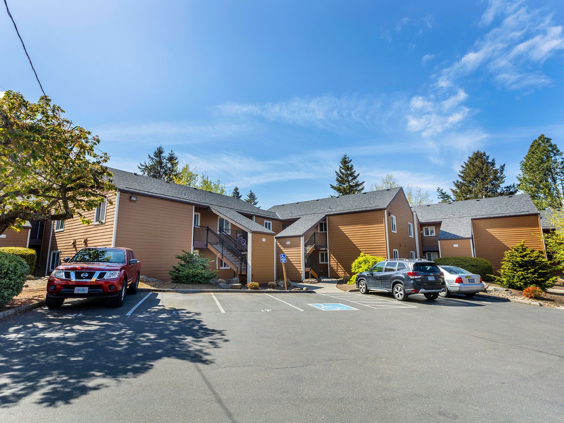 Photo of the community seen from the parking lot, showing at least one handicap spot