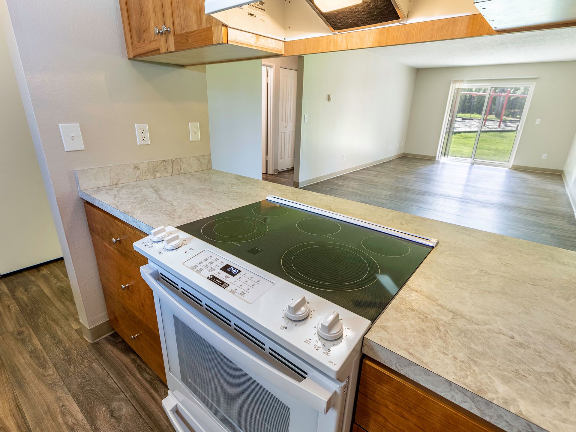 Photo of the kitchen with a counter for barstools and the living room in the background