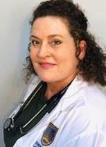 Woman in white coat with stethoscope, looking at the camera.