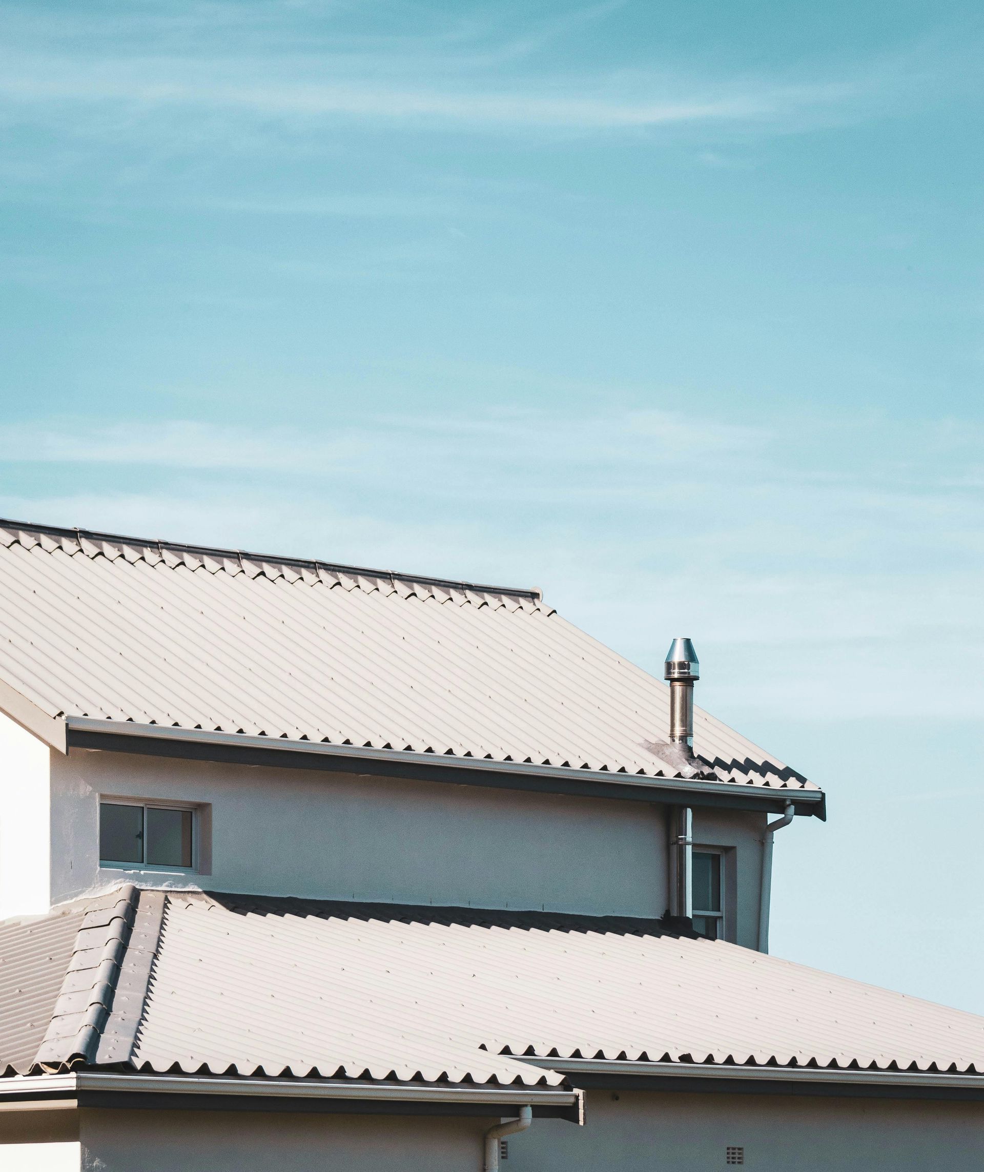 A house with a white roof and a blue sky in the background