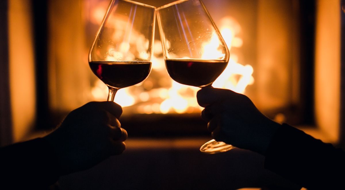 Clicking wine glasses over fire