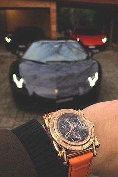 A person is wearing a luxurywatch in front of a lamborghini.