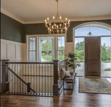 A hallway with stairs and a chandelier hanging from the ceiling