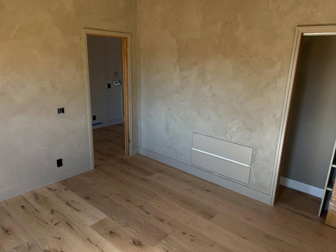 An empty room with a wooden floor and a door.