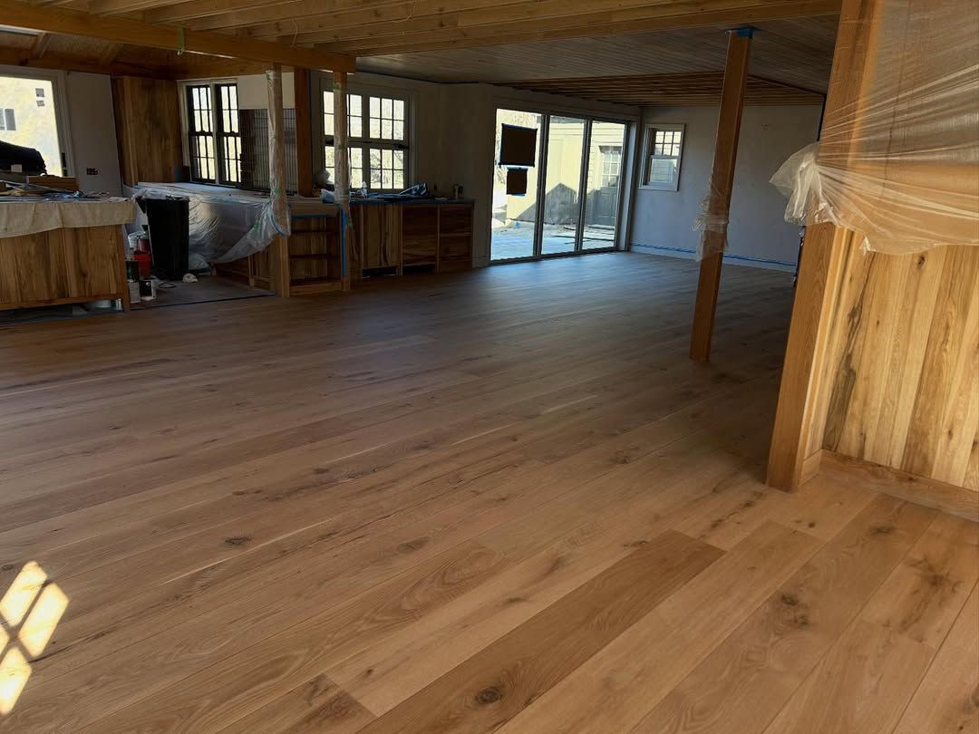 A large room with a wooden floor and a lot of windows.