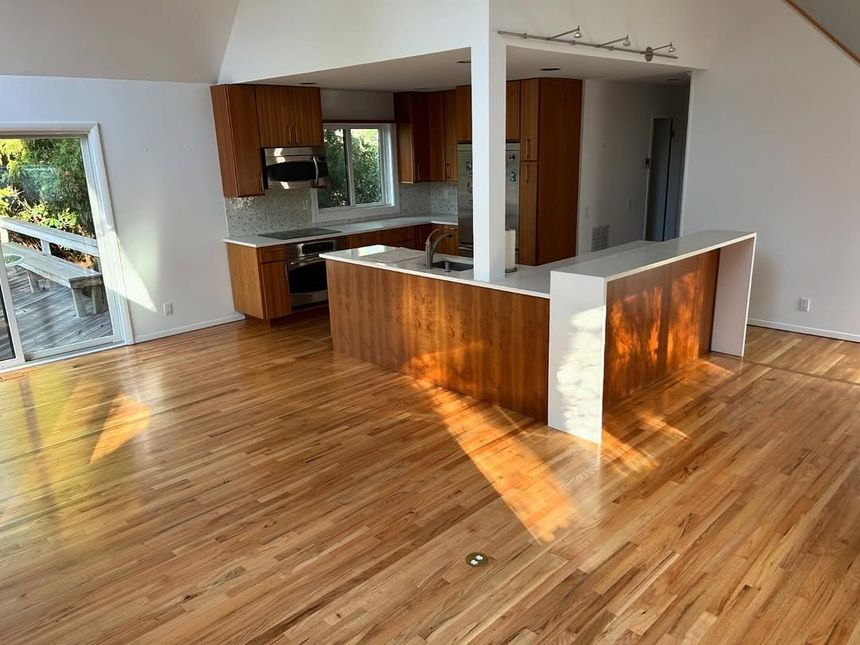 A kitchen with hardwood floors and a sliding glass door.