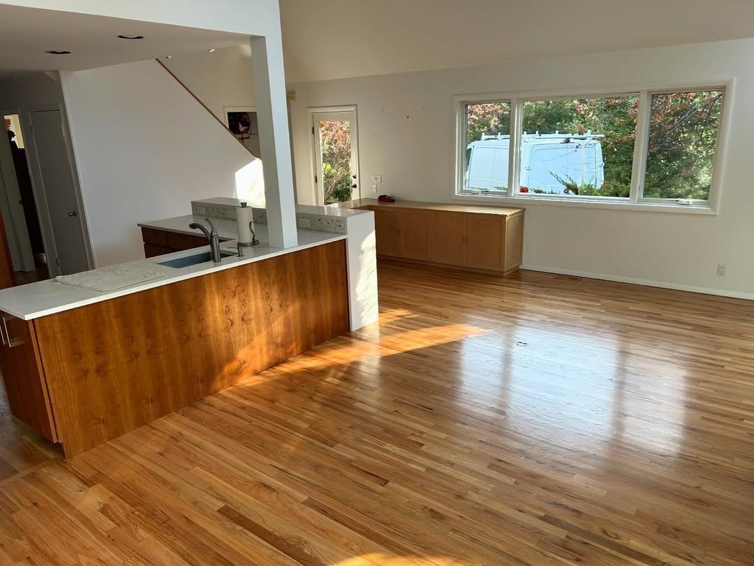 A living room with hardwood floors and lots of windows.