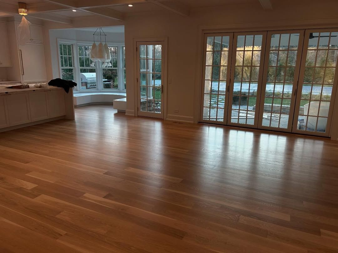 A large empty room with hardwood floors and sliding glass doors.
