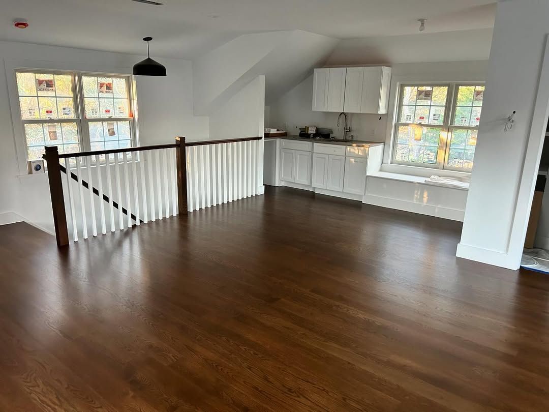 A living room with hardwood floors and white cabinets.
