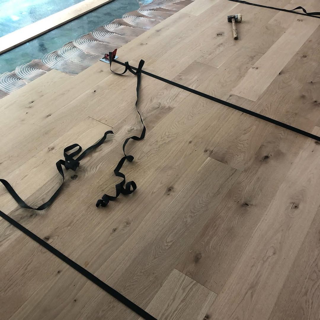 A piece of wire is laying on a wooden floor.