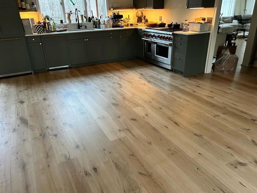 A kitchen with a wooden floor and stainless steel appliances.