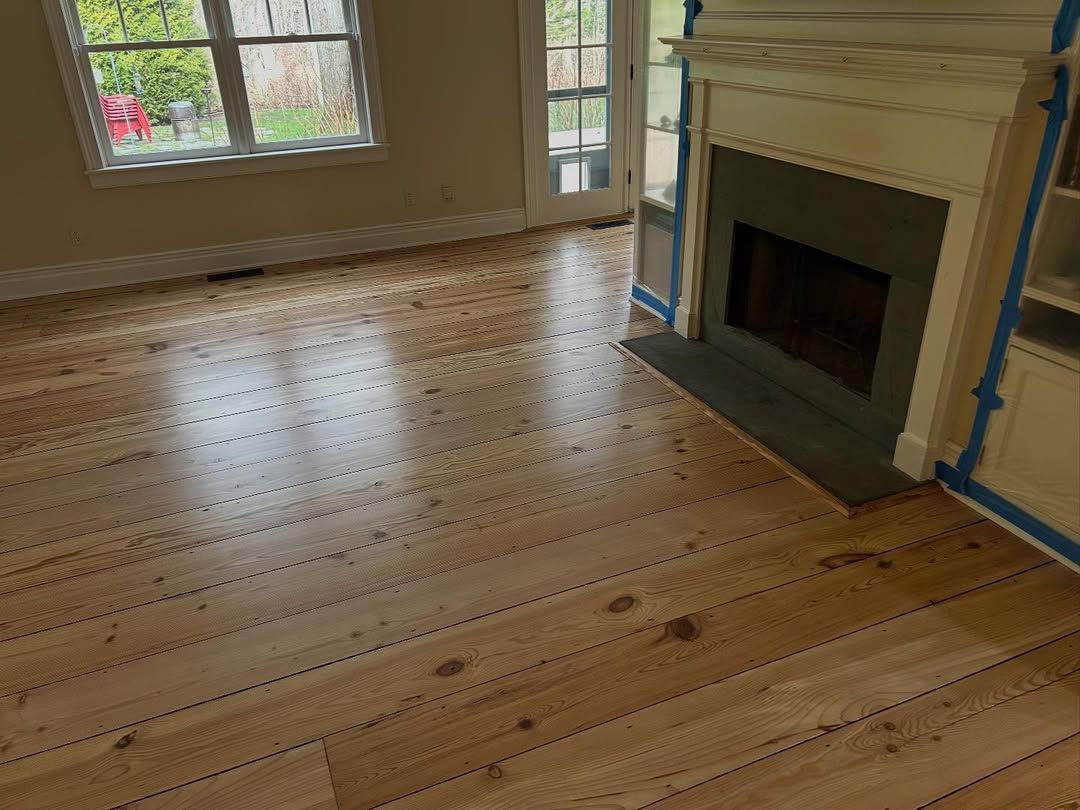 A living room with hardwood floors and a fireplace.