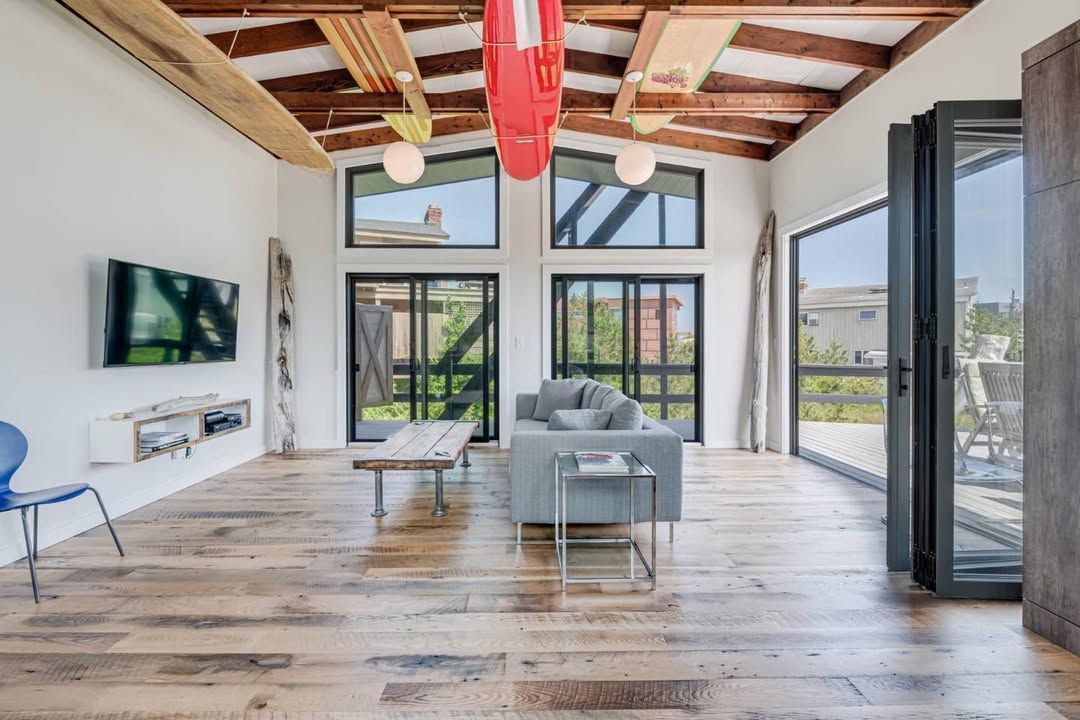 A living room with a couch and a television on the wall.