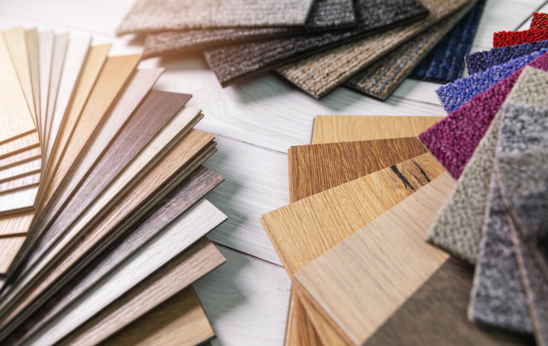 There are many different types of wood and carpet samples on the table.