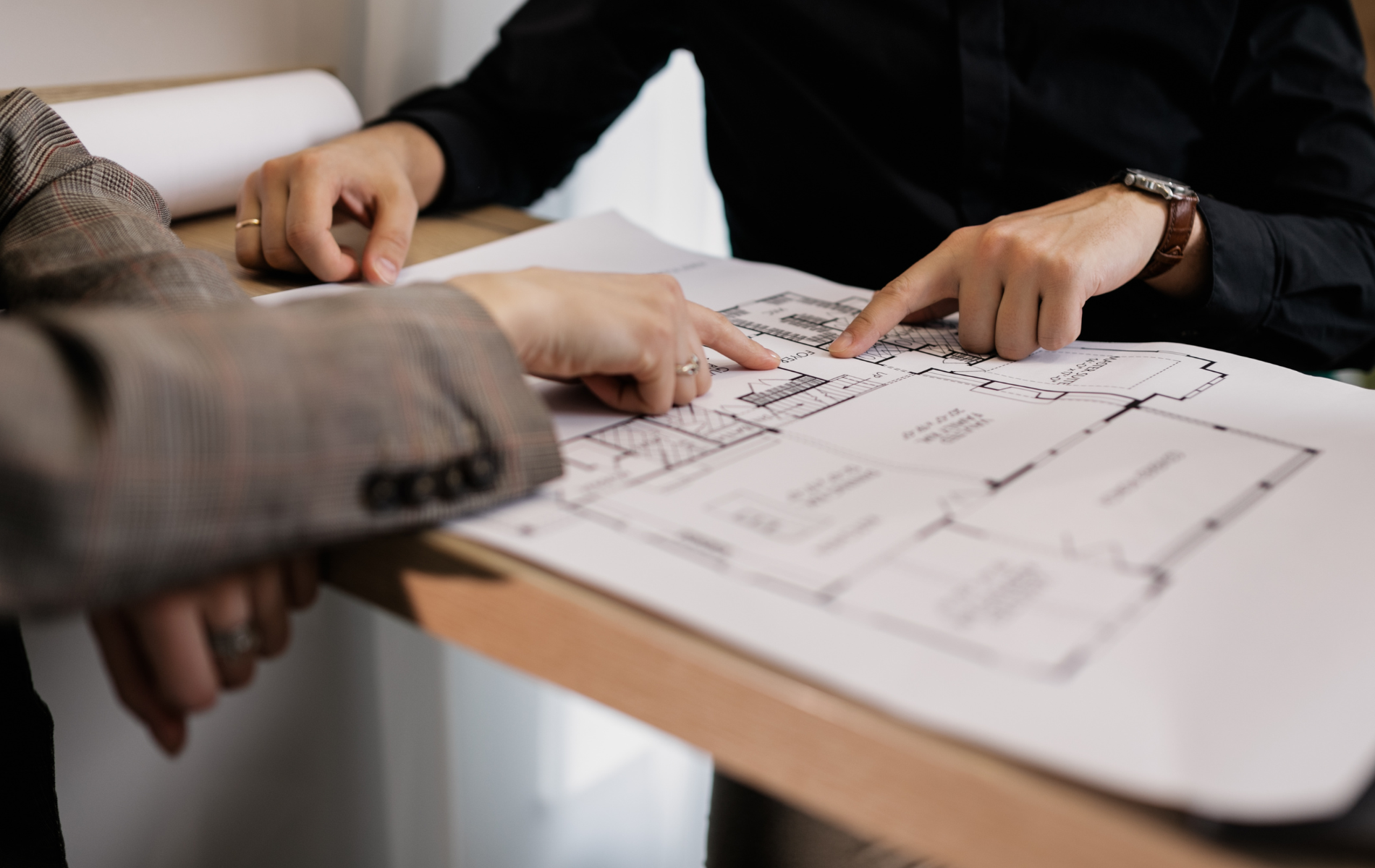 Two people are sitting at a table looking at a floor plan.