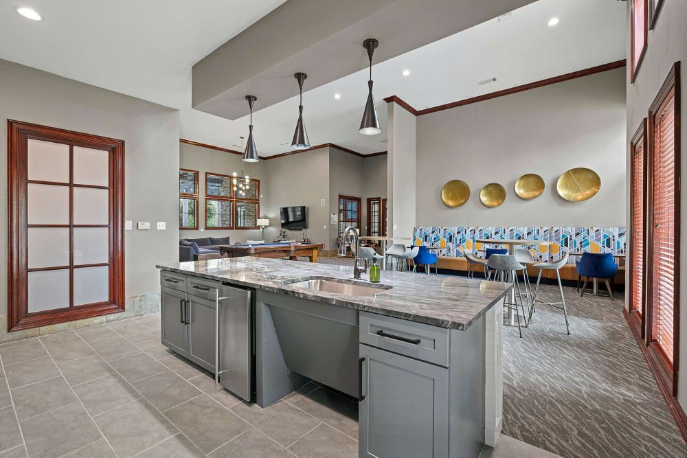 a clubhouse kitchen with a large island in the middle of the room at Marquis Parkside in Austin, TX.