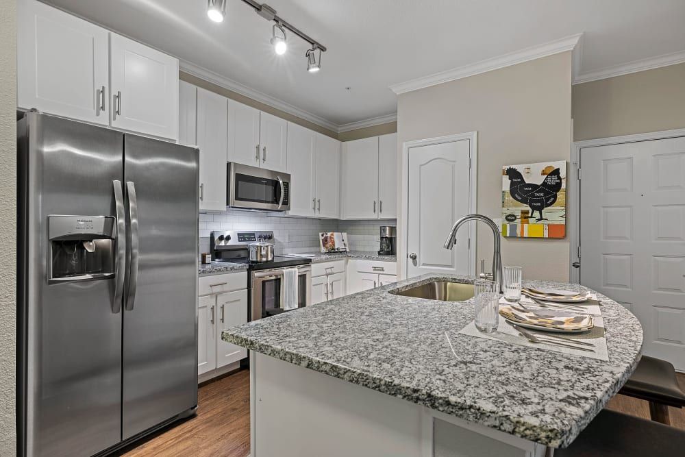 a kitchen with stainless steel appliances and granite counter tops at Marquis Parkside in Austin, TX.