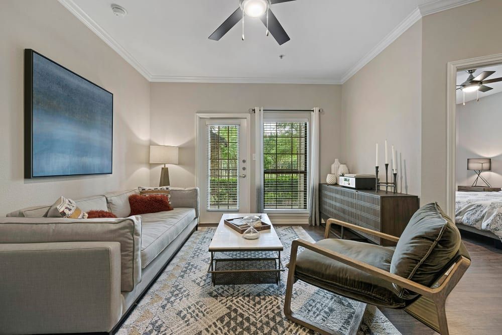 a living room with a couch, chair, coffee table, and ceiling fan at Marquis Parkside in Austin, TX.
