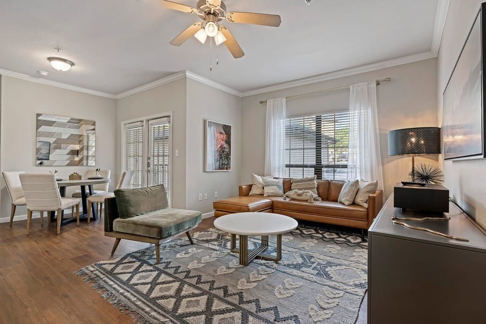 a living room filled with furniture and a ceiling fan at Marquis Parkside in Austin, TX.