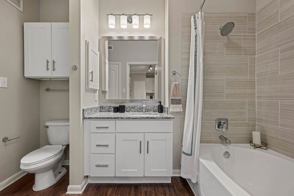a bathroom with a toilet, sink, tub, and shower at Marquis Parkside in Austin, TX.