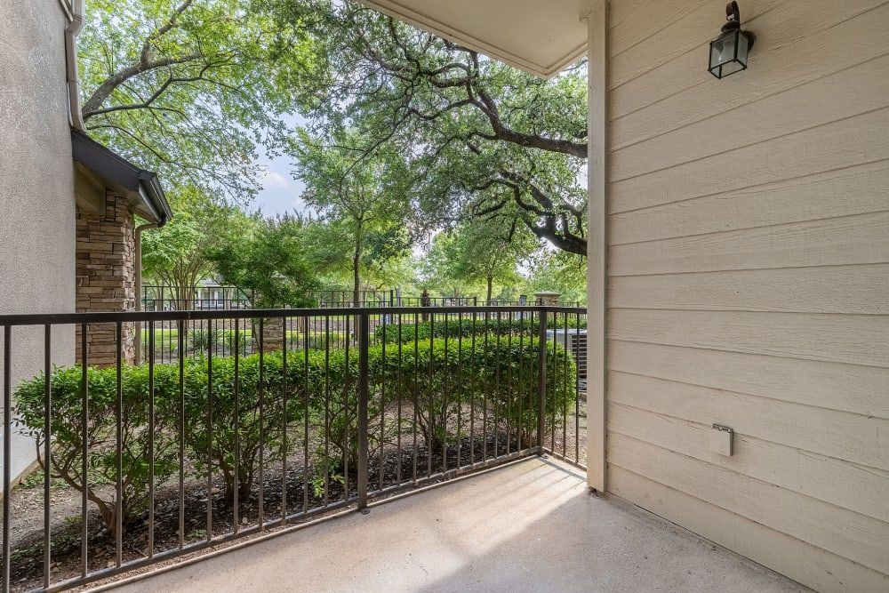 a balcony with a metal railing and trees in the background at Marquis Parkside in Austin, TX.