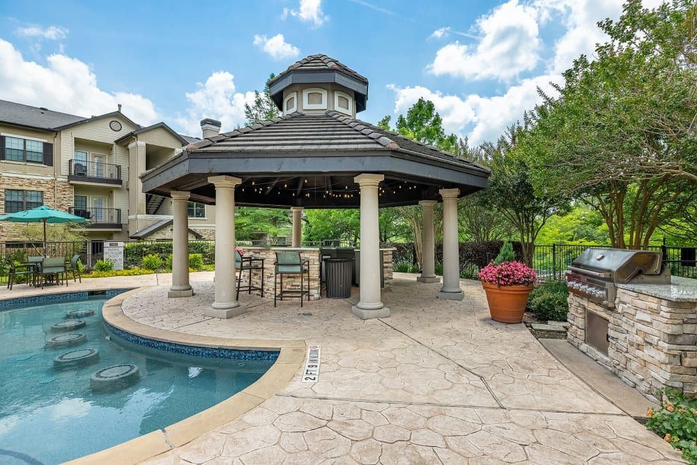 a gazebo next to a swimming pool with a grill at Marquis Parkside in Austin, TX.