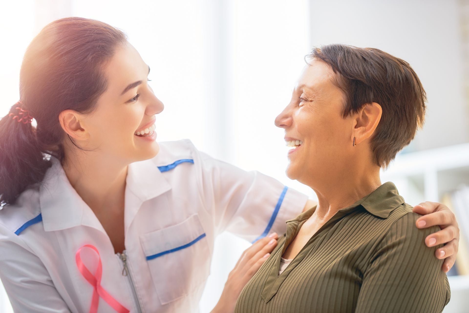 A female nurse is holding hands with a cancer patient.