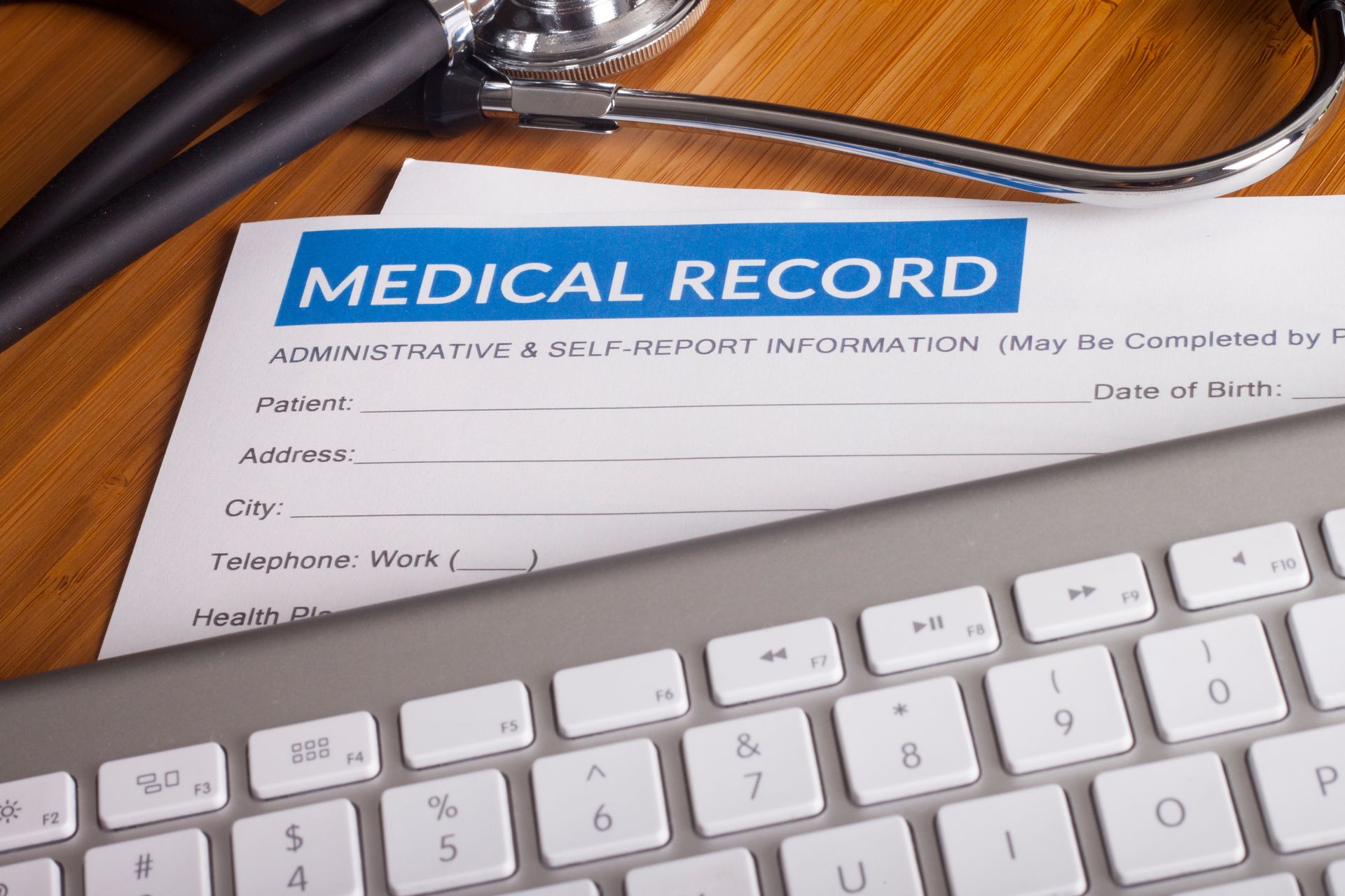 A medical record is sitting on top of a keyboard