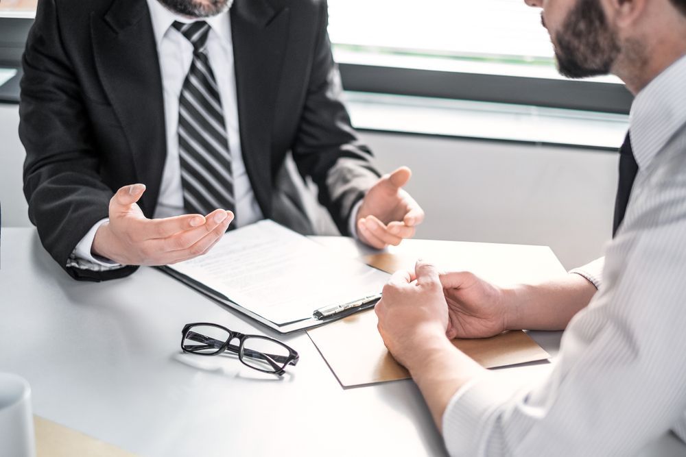 Two men are sitting at a table having a conversation.