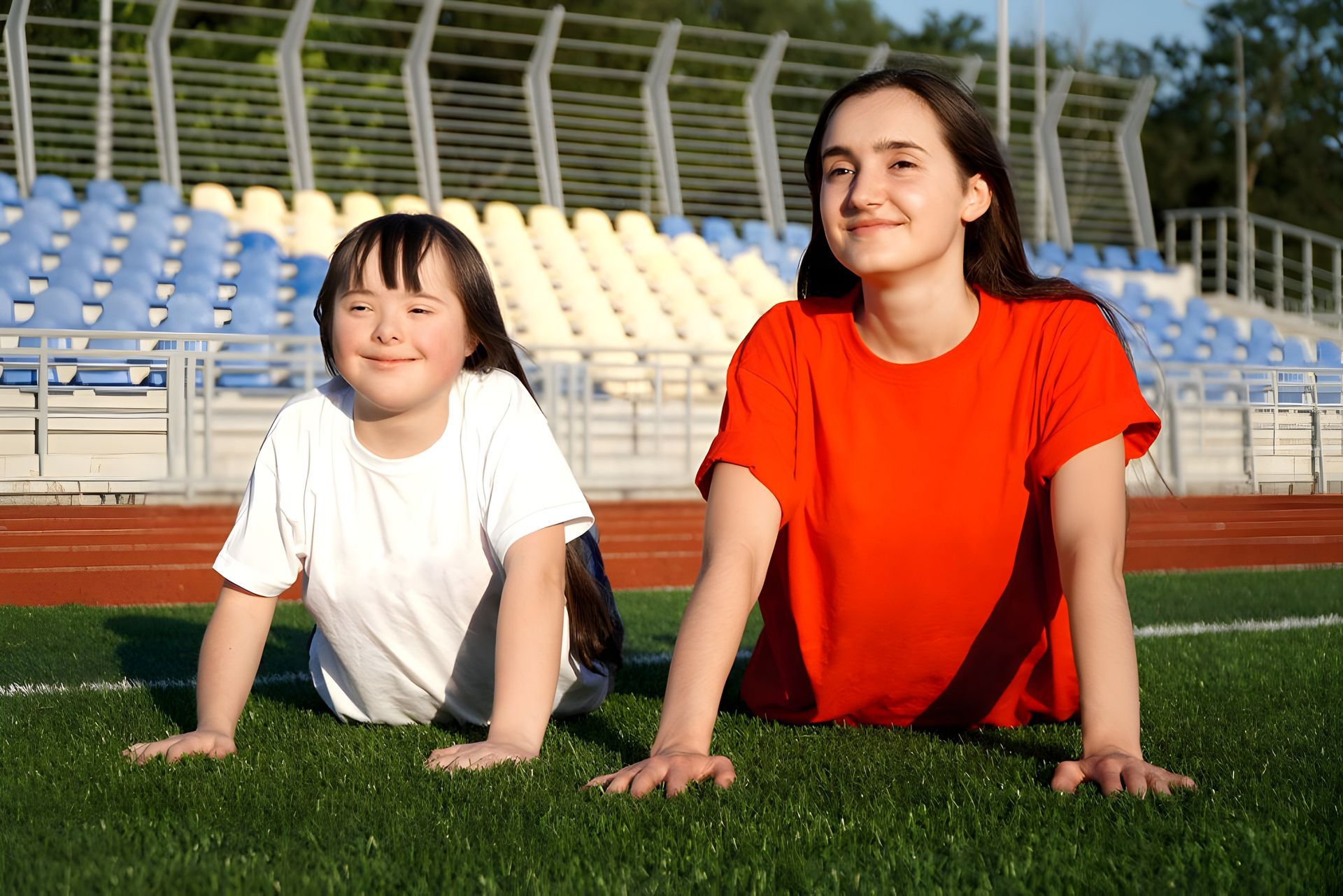 Two Girls Relaxing on Grass at a Soccer Field — Adaptive Care Pty Ltd In Tarneit, VIC