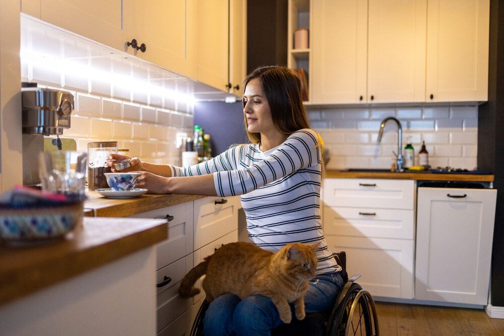 A Woman in a Wheelchair Prepares Coffee — Adaptive Care Pty Ltd In Pakenham, VIC