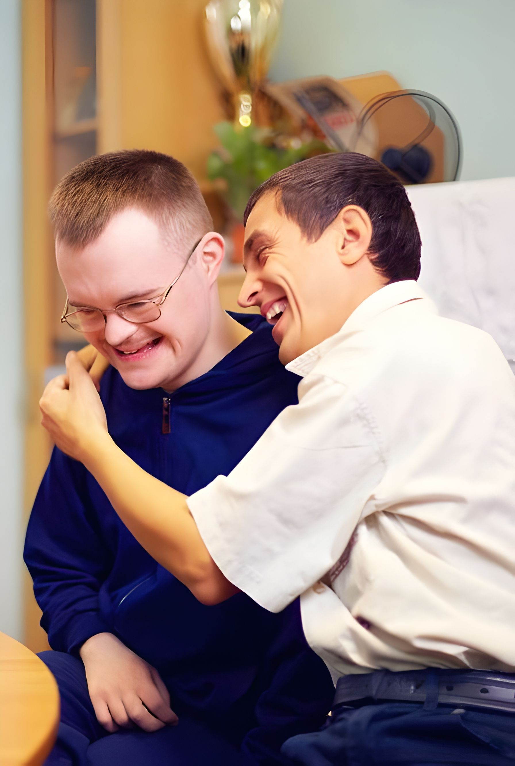 Two Men Are Sitting Next to Each Other and Laughing — Adaptive Care Pty Ltd In Tarneit, VIC