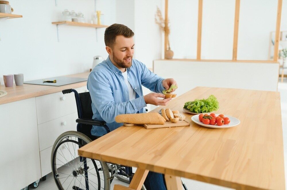 Man in a Wheelchair Making a Sandwich — Adaptive Care Pty Ltd In Preston, VIC