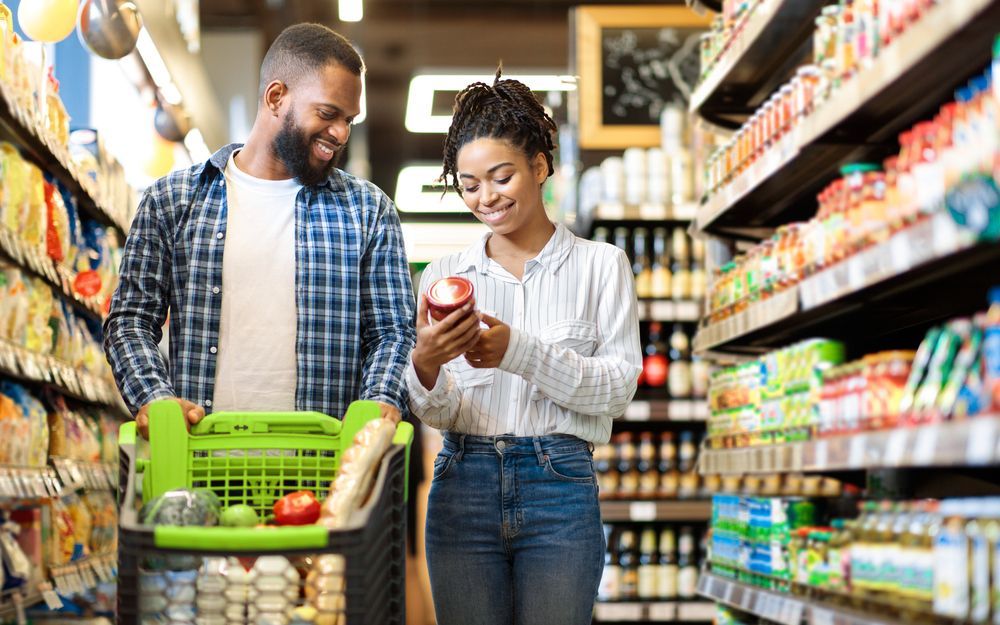 Family Buying Food In Supermarket Shop Walking Pushing Cart And Choosing Groceries Together. ©ProstockStudio