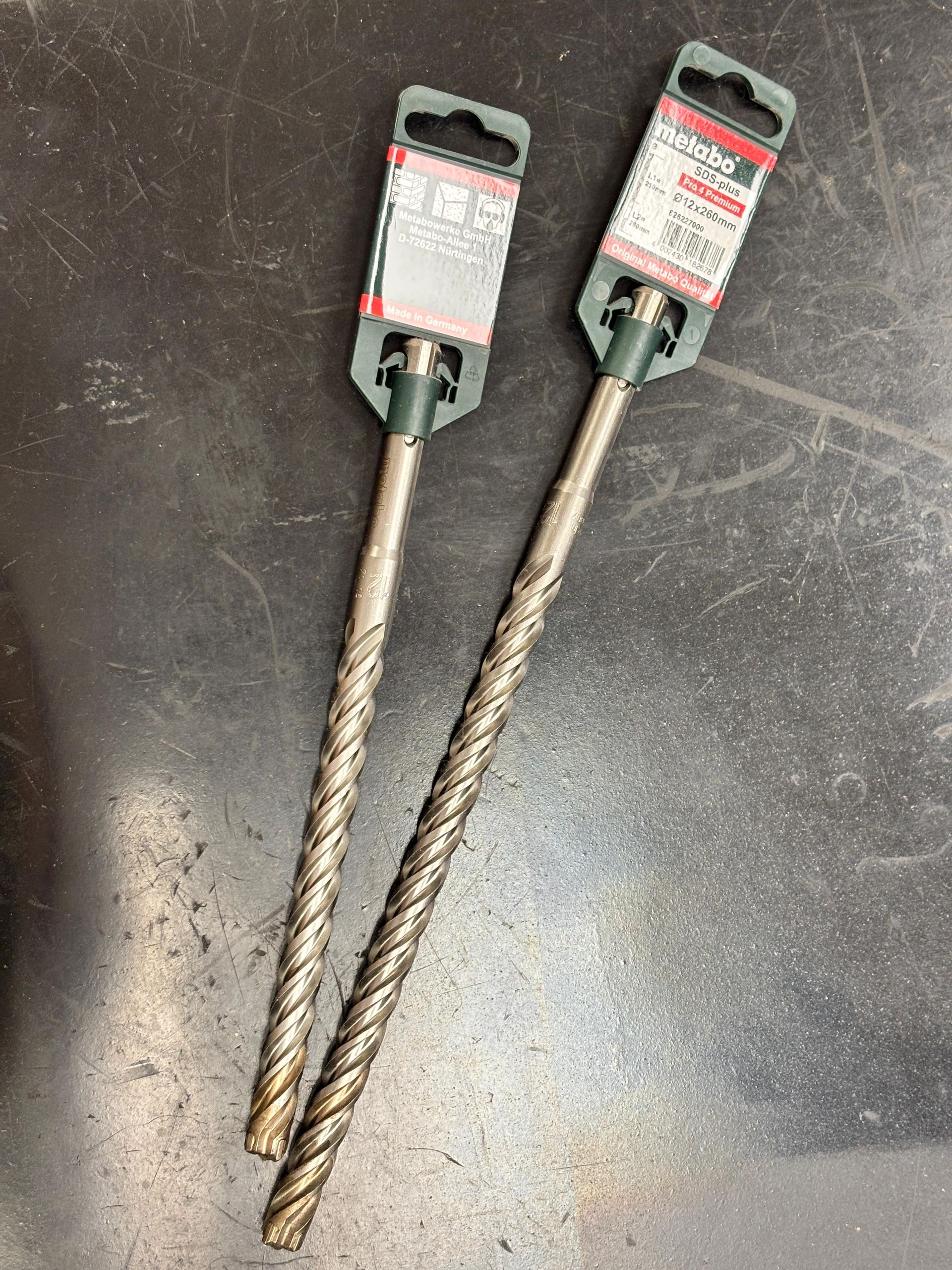 Due punte da trapano sono appoggiate su un tavolo.