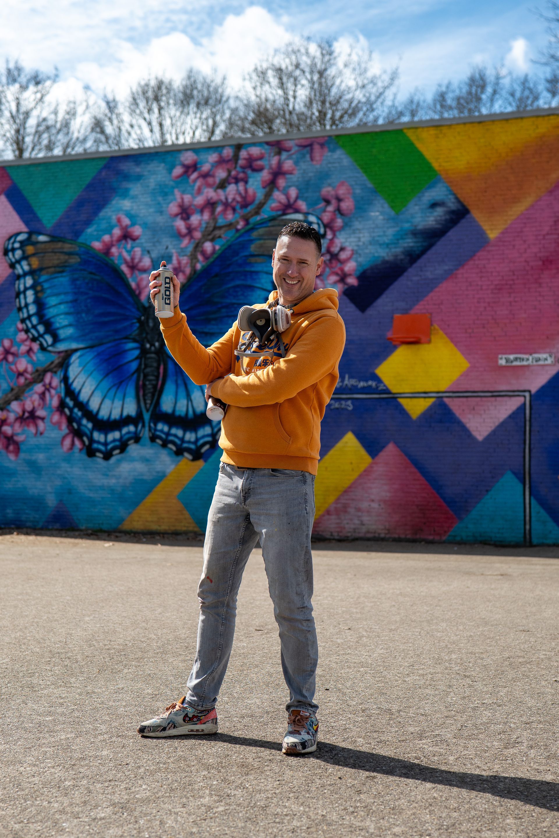 Vrouw met gitaar in de hand, leunend tegen een rode klassieke auto, in een gitaarwinkel.