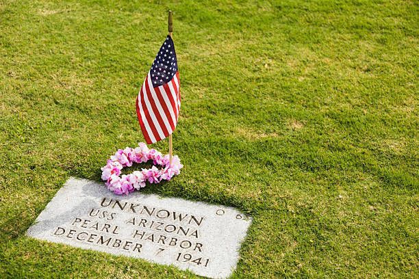 A grave with a wreath and an american flag on it.