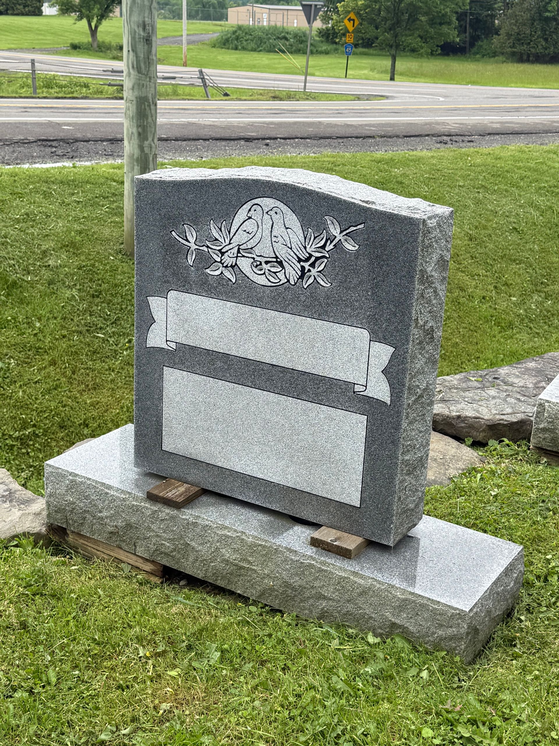 A gravestone is sitting in the middle of a grassy field.
