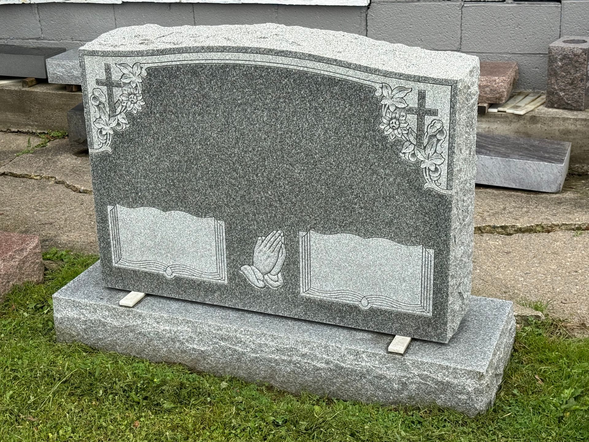 A gravestone is sitting on top of a lush green field.