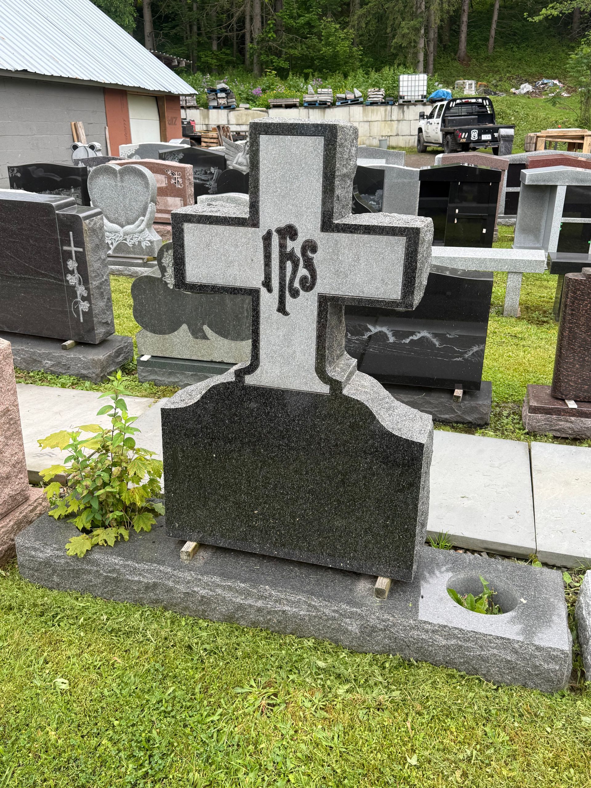A gravestone with a cross on it in a cemetery