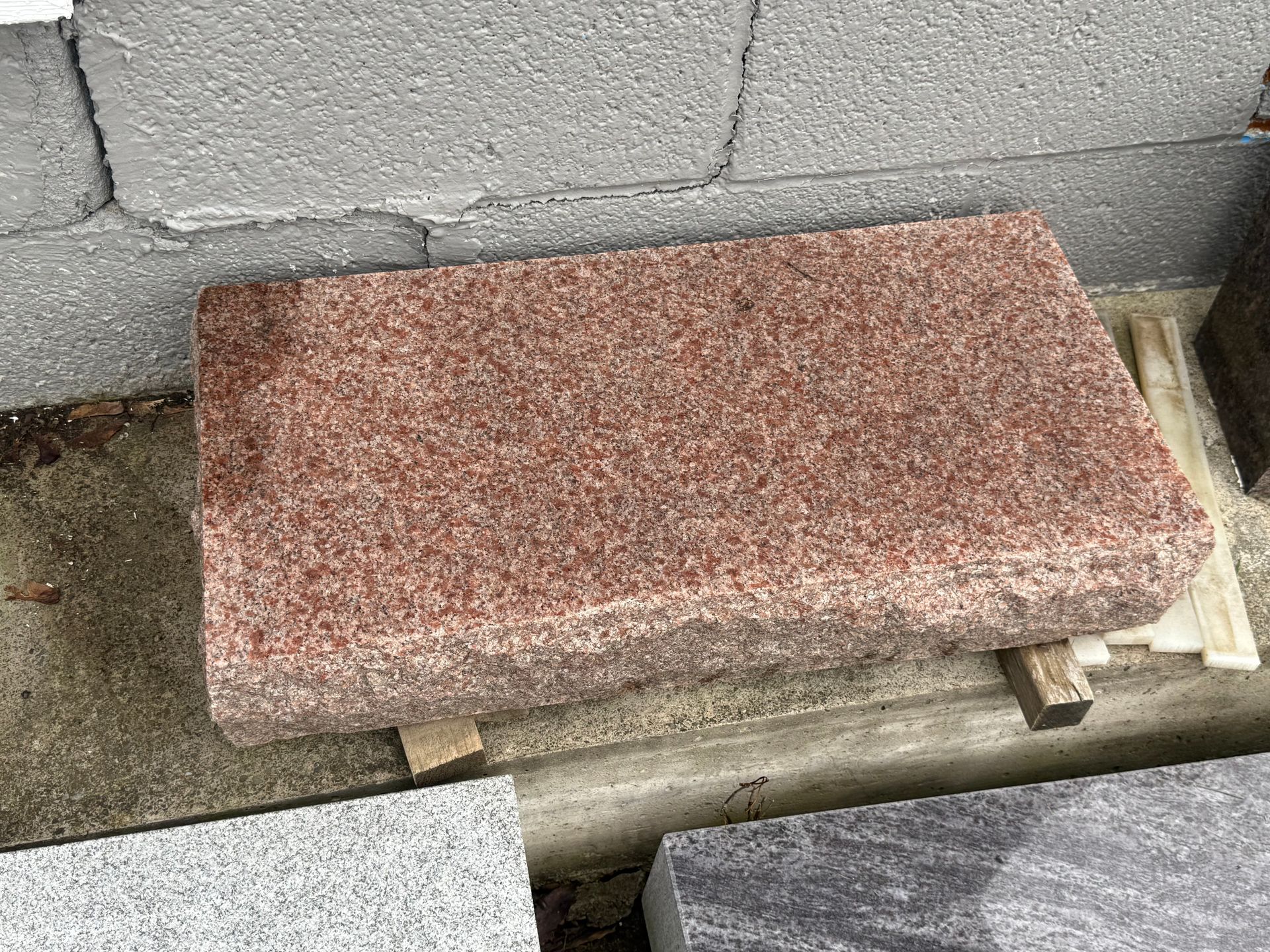 A red granite slab is sitting on top of a wooden pallet.