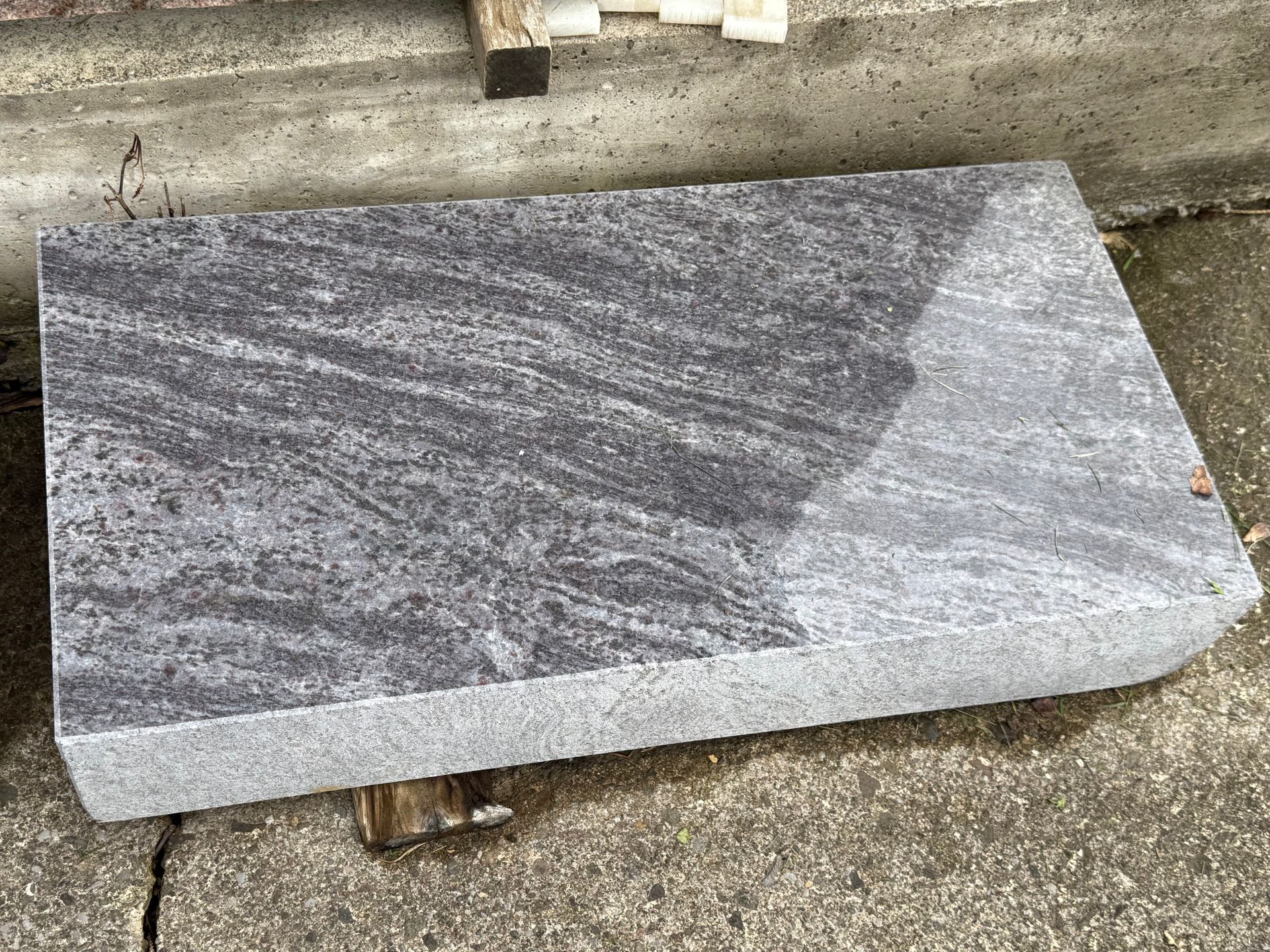 A large piece of granite is sitting on the ground.