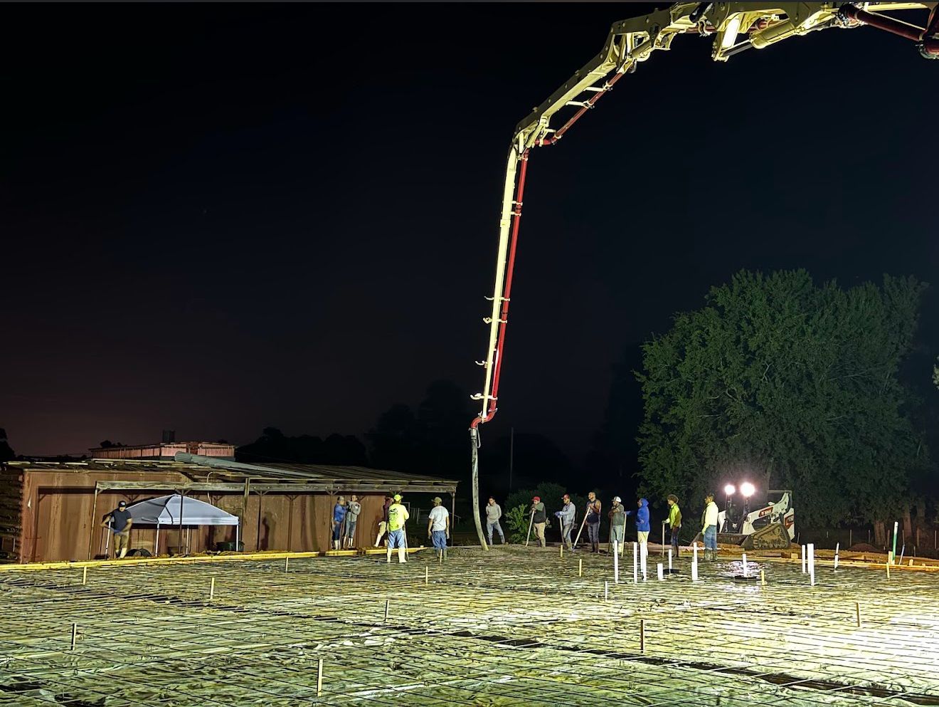 A group of construction workers are working on a construction site at night