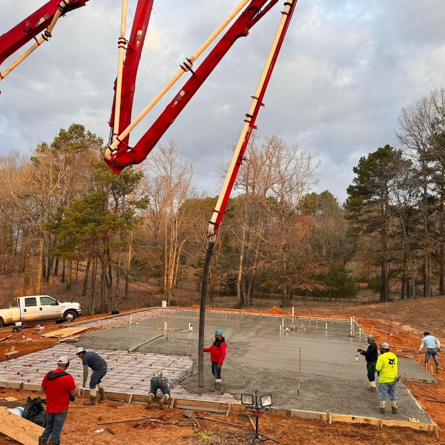 A concrete pump is being used to pour concrete on a construction site