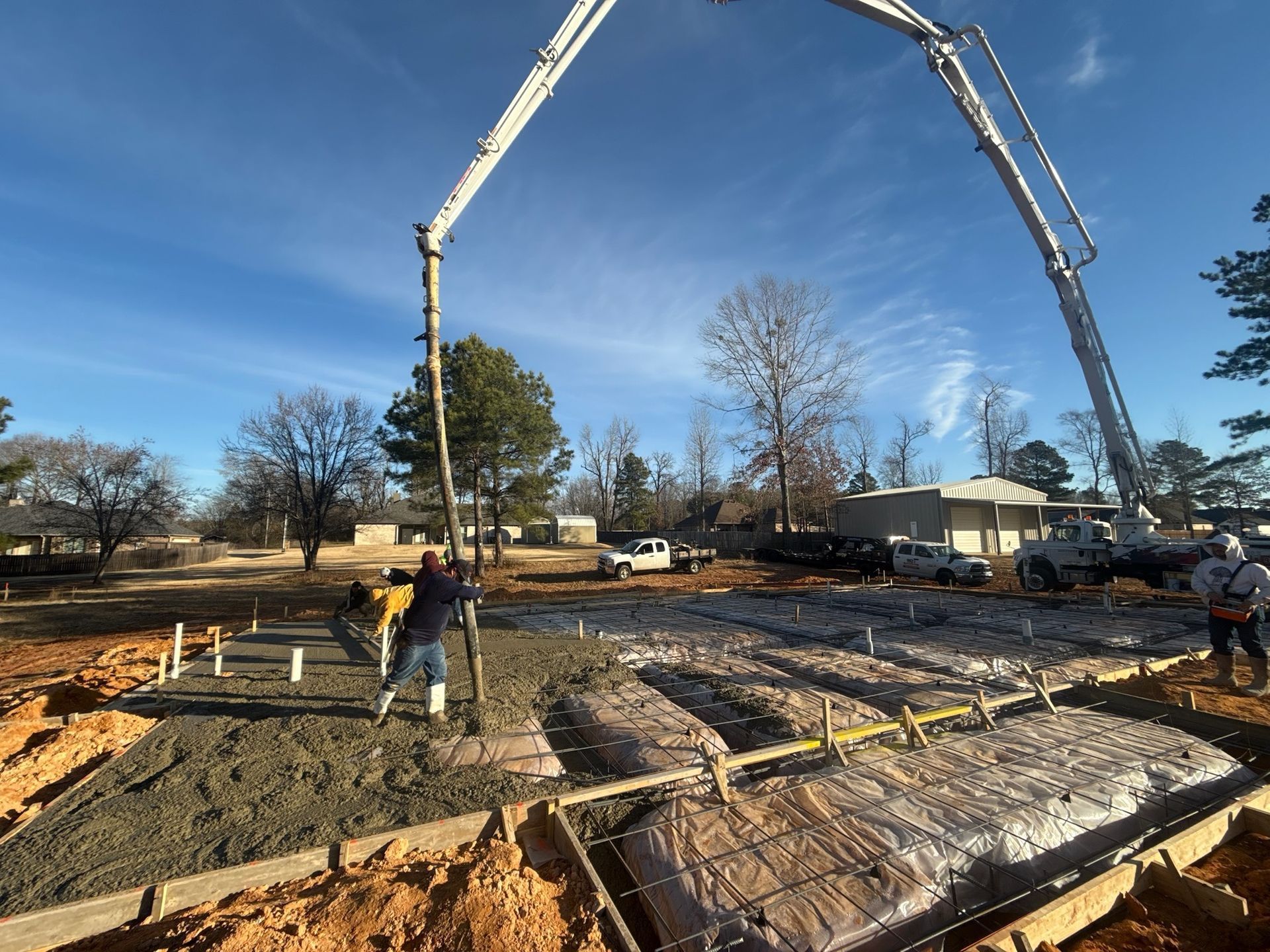 A concrete pump is being used to pour concrete on a construction site.