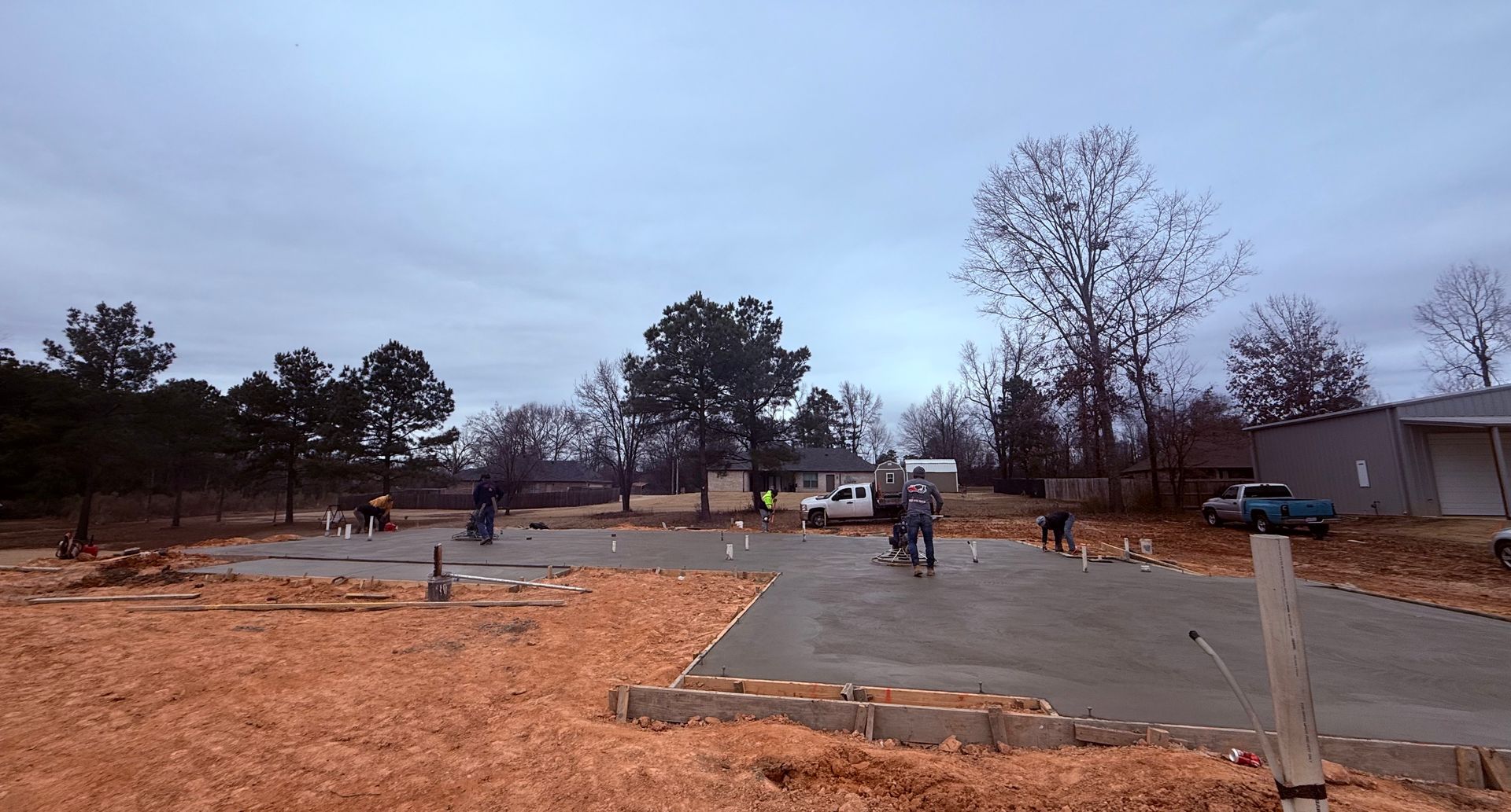 A construction site with a lot of dirt and trees in the background